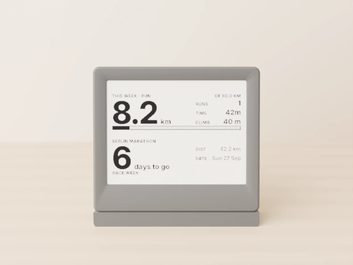 The e-paper display in its dark graphite shell, seen straight on, showing this week’s run of 8.2 km of 60.0 with 1 run, 42m and 40 m climbed, and below it Berlin Marathon, race week, 6 days to go, 42.2 km, Sun 27 Sep.
